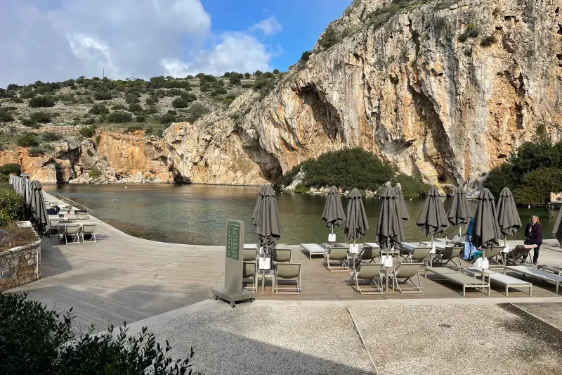 Sun loungers and folded umbrellas on the lake-front deck at Lake Vouliagmeni