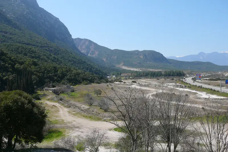 A panoramic view of the Thermopylae pass, with mountains rising above the valley and the modern highway running through it