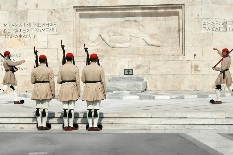 Evzones in traditional uniform marching past the Tomb of the Unknown Soldier during the changing of the guard